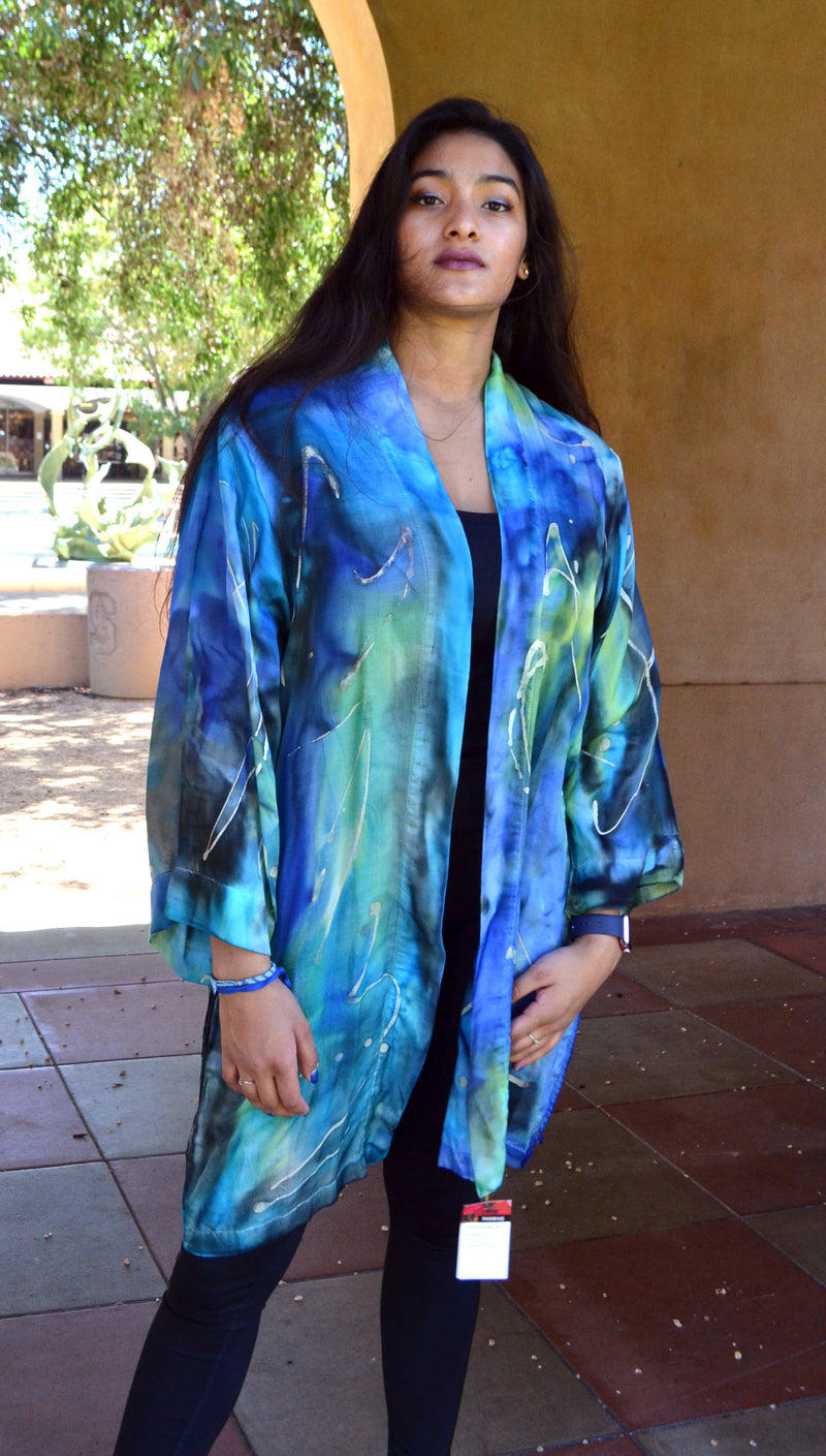 This long blue Kimono Jacket is hand painted on silk cotton fabric. It has a beautiful drape and long slits on the sides for easy movements and better fit. It fits S-XL. Larger sizes are made custom when ordered.