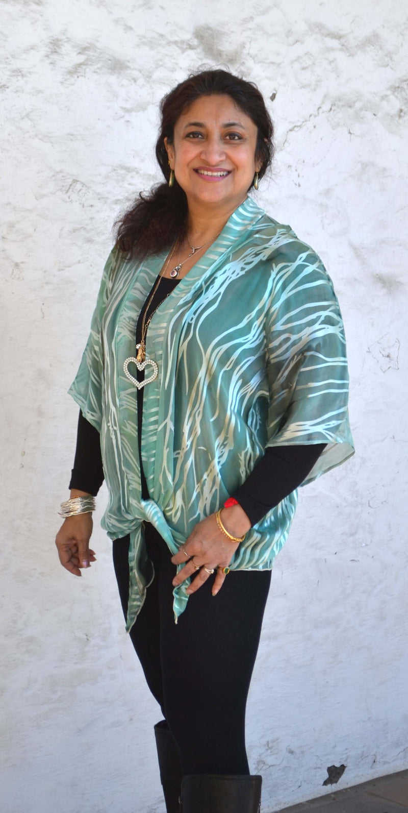 This jade green hand painted devore kimono jacket is available in sizes S-L. It can be hand washed or dry cleaned. These jackets have a scarf like edge and can be tied at the waist. You can wear it with solid sweaters, camisoles. dresses. A matching Poshaq silk camisole can be made separately once ordered.