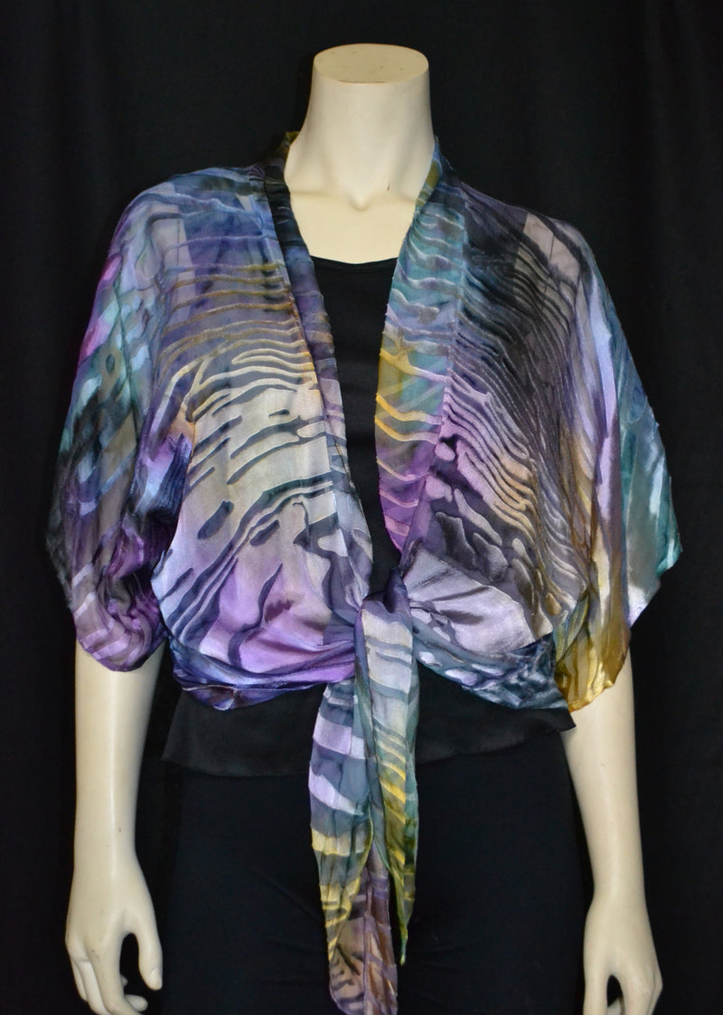 This Purple and green hand painted devore kimono jacket is available in sizes S-L. It can be hand washed or dry cleaned. These jackets have a scarf like edge and can be tied at the waist. You can wear it with solid sweaters, camisoles, dresses. A matching Poshaq silk camisole can be made separately once ordered. The jackets are available in sizes 1Xl-3XL.  It can also be worn as a scarf.